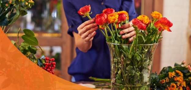 A woman taking care of roses in a vase